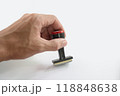 The Asian hand holding rubber stamp on white paper background. 118848638