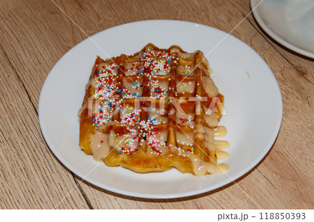 Belgian waffle with sweet toppings and white chocolate on wooden table 118850393