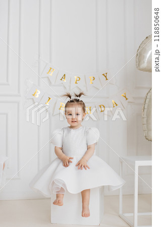 Adorable young girl celebrating birthday with decorations 118850648