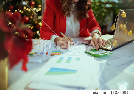 Business owner woman in green office with Christmas tree working 118850890
