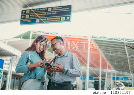 A Happy Couple Enjoying Their Time Together at the Airport with Mobile Devices 118851197