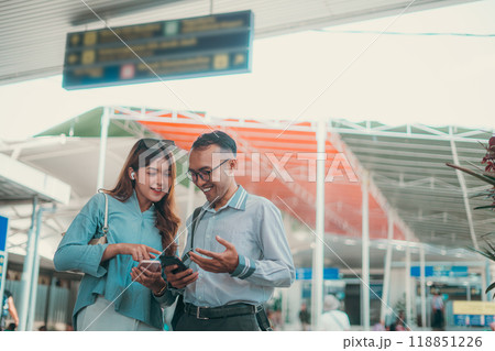 A couple happily interacting with their smartphone at a modern airport terminal 118851226