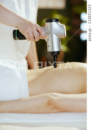 Closeup on medical massage therapist massaging clients back 118851323