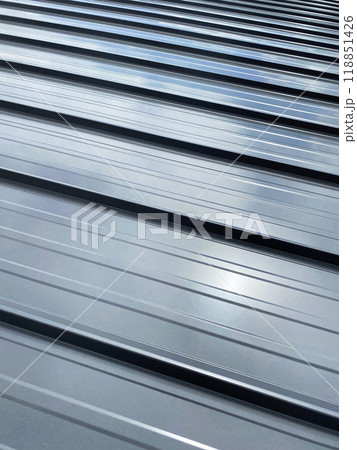 Close-up house retro roof panel with standing seam and fasteners. Modern galvanized steel roofing sheet with ribs. Classic style gray metal panel with rebate joint. Falz roofing. Building's covering Close-up house retro roof panel with standing seam and fasteners. Modern galvanized steel roofing sheet with ribs. Classic style gray metal panel with rebate joint. Falz roofing. Building's covering 118851426