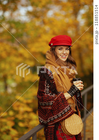 Portrait of happy trendy woman in red hat with scarf and gloves 118851514