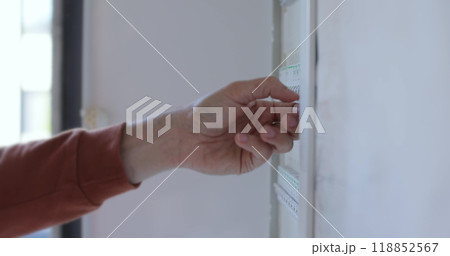 Man check and turn off circuit breakers in electrical fuse box at house. Man check and turn off circuit breakers in electrical fuse box at house. 118852567