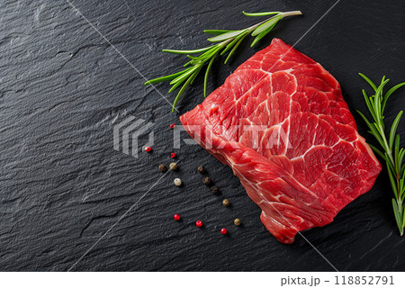 Fresh juicy beef on a black board next to a branch of rosemary, flat lay with space for animal raising farm concept Fresh juicy beef on a black board next to a branch of rosemary, flat lay with space for animal raising farm concept 118852791