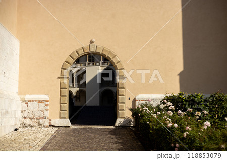 Photo of arch entrance, ancient castle exterior. Old Arch made of stone. Exit in the ancient wall. Entrance to the green park 118853079