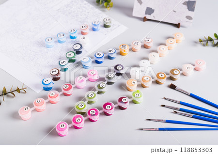 Acrylic paints, brushes and canvas for painting by numbers on the table 118853303