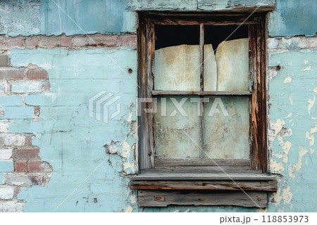 A weathered window frame shows signs of age on an old building with peeling paint in a quiet urban setting 118853973