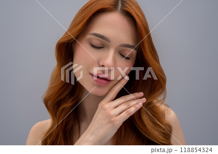 Pretty ginger long-haired young woman looking relaxed 118854324