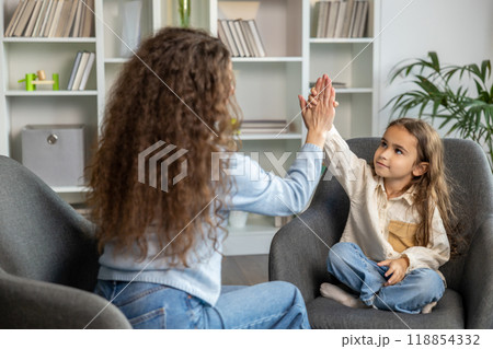 Long-haired woman and a cute little girl doing high five and looking positive 118854332