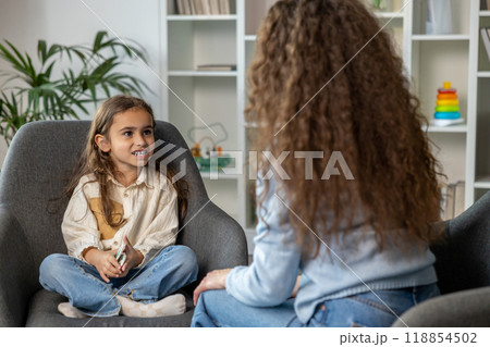 Long-haired female speech therapist having a session with a girl 118854502