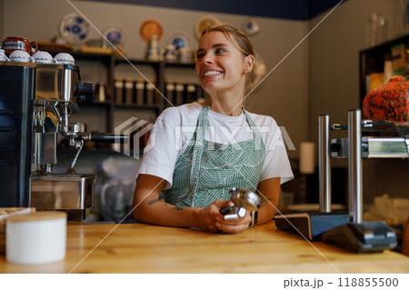 A cheerful barista expertly creating delicious beverages at a cozy local coffee shop A cheerful barista expertly creating delicious beverages at a cozy local coffee shop 118855500