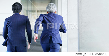 オフィスを二人で走るビジネスパーソンの後ろ姿 118858847