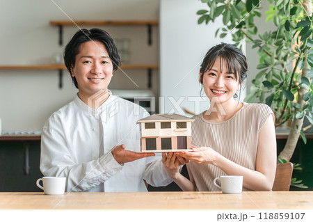 住宅模型を持つ若い夫婦(マイホーム・相談会・新居・家づくり) 住宅模型を持つ若い夫婦(マイホーム・相談会・新居・家づくり) 118859107