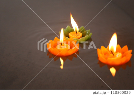 Candles of Krathong with flames floating on the water. Candles of Krathong with flames floating on the water. 118860029