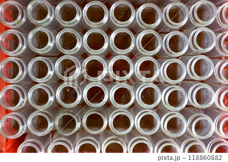 Top view of many glass bottles with their caps open and lined up. 118860882