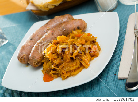 Image of tasty meat sausages served with braised cabbage 118861703