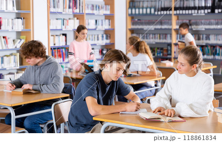 Schoolchildren write out a synopsis from the textbook 118861834