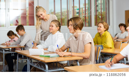 Teenagers sitting at desks in classroom during lesson Teenagers sitting at desks in classroom during lesson 118862056