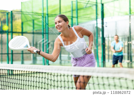 Young woman padel tennis player trains on the outdoor court Young woman padel tennis player trains on the outdoor court 118862072