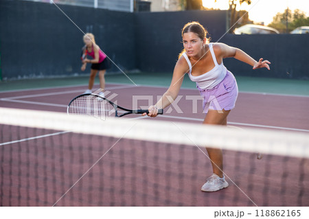 Sporty woman plays tennis on court. View through tennis net 118862165