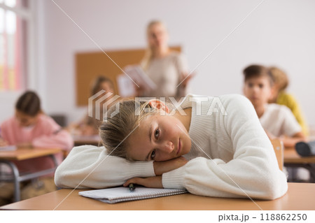 Teenager girl lying on table during lesson 118862250