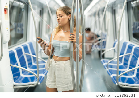 Young girl standing in wagon holding phone in hand 118862331