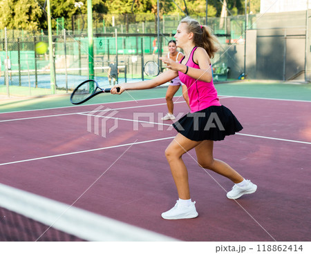 Girl playing tennis match during training on court Girl playing tennis match during training on court 118862414