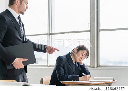 授業中にやる気のない生徒を注意する先生 118862475