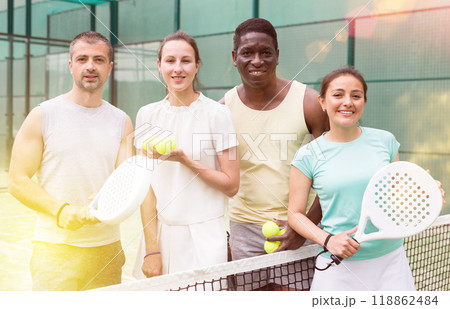 Four paddle tennis players posing on court Four paddle tennis players posing on court 118862484