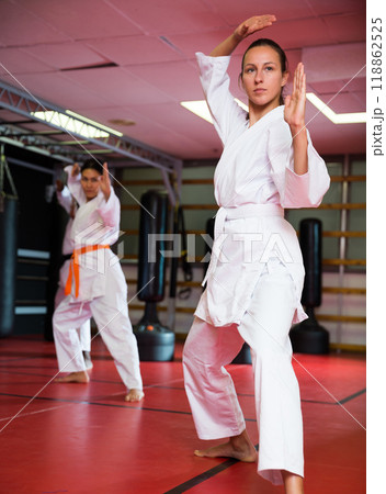 Woman in kimono showing fight stance during karate training 118862525