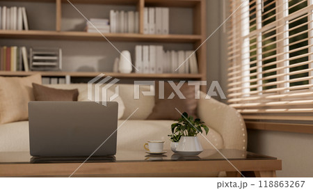 A close-up of a laptop on a coffee table in a contemporary living room. A close-up of a laptop on a coffee table in a contemporary living room. 118863267