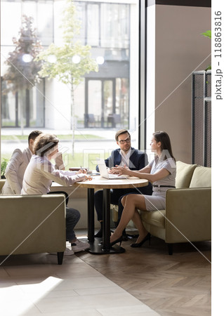 Business partners discussing deal in co-working space, sitting on couches 118863816