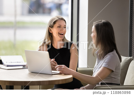 Happy joyful business colleagues sharing laptop at table, talking Happy joyful business colleagues sharing laptop at table, talking 118863898