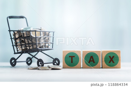 TAX is written on a wooden block and coins in a shopping cart on a wooden table against a bright white background. Commercial tax and Financial planning, savings, and wise money management. TAX is written on a wooden block and coins in a shopping cart on a wooden table against a bright white background. Commercial tax and Financial planning, savings, and wise money management. 118864334