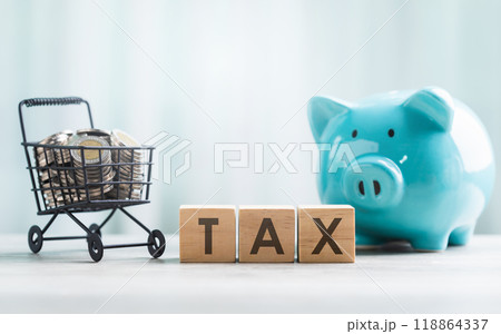 TAX is written on a wooden block and coins in a shopping cart on a wooden table against a bright white background. Commercial tax and Financial planning, savings, and wise money management. TAX is written on a wooden block and coins in a shopping cart on a wooden table against a bright white background. Commercial tax and Financial planning, savings, and wise money management. 118864337