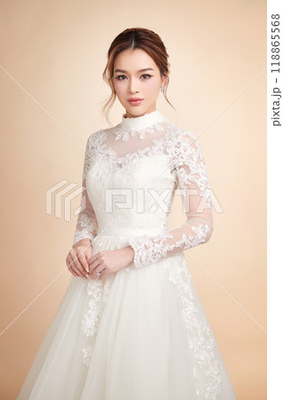 Beautiful young asian woman in wedding dress on beige background, 118865568