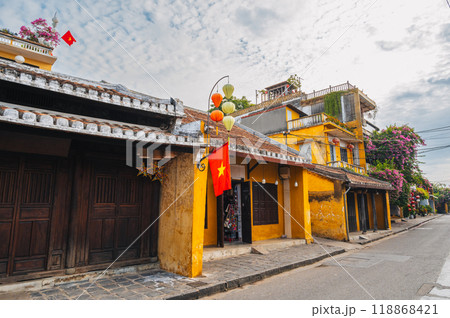 Streets with traditional ancient yellow houses in old town in Hoi An city in Vietnam at summer day 118868421