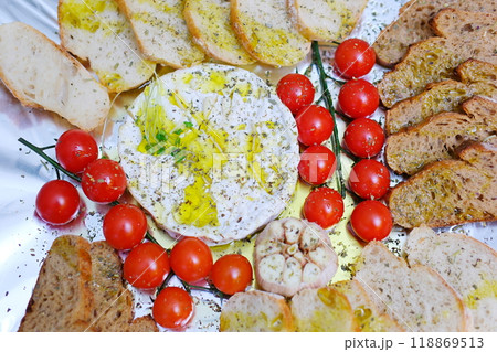 Preparation of a delicious starter of ham, cheese, red grapes, purple grapes, cherry tomato, jelly, fresh olives. Delicious board of hams and cheeses with fruit to share at a table gourmet party Preparation of a delicious starter of ham, cheese, red grapes, purple grapes, cherry tomato, jelly, fresh olives. Delicious board of hams and cheeses with fruit to share at a table gourmet party 118869513