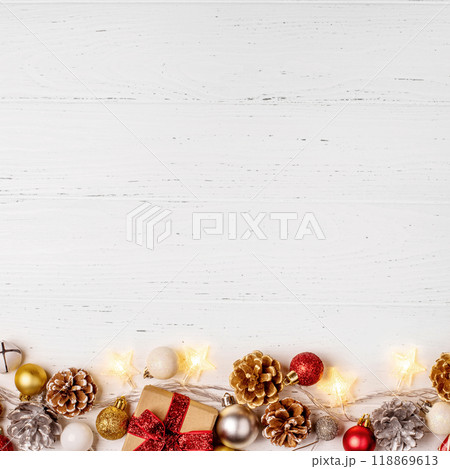 Christmas decorations and a gift box on a white table. Christmas decorations and a gift box on a white table. 118869613