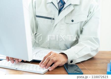 パソコン操作をする作業服の男性 118872623