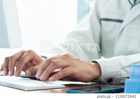 パソコン操作をする作業服の男性 パソコン操作をする作業服の男性 118872642