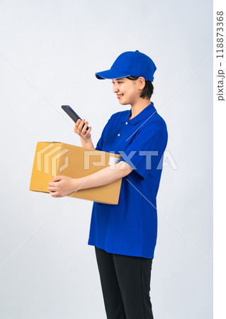 荷物とスマホを持つ作業服を着た女性 デリバリースタッフ 配達員 作業員 荷物とスマホを持つ作業服を着た女性 デリバリースタッフ 配達員 作業員 118873368