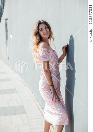 Beautiful blonde woman smiling in summer dress on a walk Beautiful blonde woman smiling in summer dress on a walk 118877031