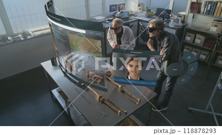 Two archaeologists in VR headsets study skeleton remains using augmented reality Two archaeologists in VR headsets study skeleton remains using augmented reality 118878293