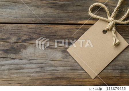 Crafting a rustic gift tag tied with twine on weathered wooden surface 118879436
