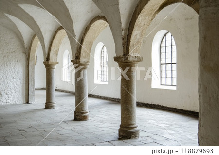 Elegant interior of a historic building showcasing arches and stone columns under soft daylight 118879693