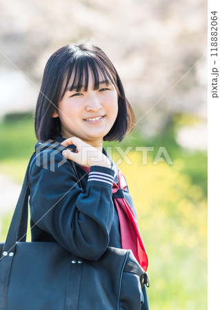 桜の咲く春に通学する笑顔の女子高校生 118882064